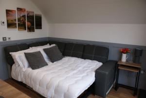 a large bed with white sheets and gray pillows at Knockan in Keith