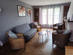 ein Wohnzimmer mit Sofa, Stühlen und einem Tisch in der Unterkunft La Tribu de Beauval 6ch grand terrain et parking privé in Saint-Aignan