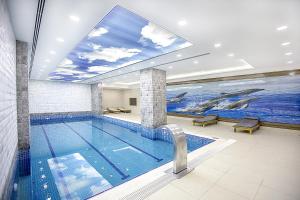 ein Swimmingpool mit einem Delfingemälde an der Wand in der Unterkunft Mitannia Regency Hotel in Diyarbakır