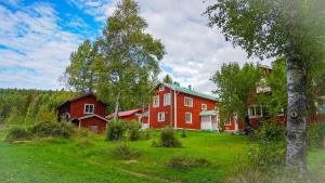 a large red house in a field with trees at Annexet Orrabackens in Järvsö +40 photos