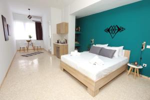 Old Town Hall Suites and Apartments في أثينا: غرفة نوم بسرير كبير بجدار ازرق