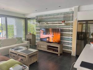 a living room with a couch and a tv at Sea Breeze Villa at Sani in Sani Beach