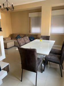 - un salon avec une table et des chaises blanches dans l'établissement The Queen, à Luanda