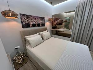 a bedroom with a white bed and a mirror at Supreme Secret Suite in Alexandroupoli