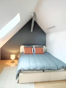 una camera da letto con letto con lenzuola blu e cuscini arancioni di Da Vinci - Studio Charmant a Amboise