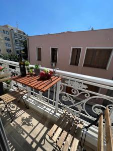 a balcony with a wooden table and chairs on a building at Supreme Secret Suite in Alexandroupoli