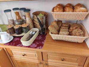 - une table avec des paniers de pain et des paniers de viennoiseries dans l'établissement Gästehaus Einzinger, à Krems an der Donau