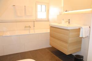 y baño con bañera, lavabo y bañera tubermottermott. en Ferienhaus Alwine, en Jork