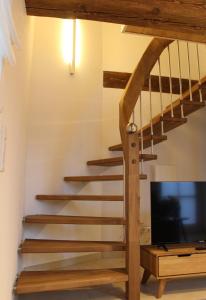 sala de estar con escalera y TV de pantalla plana en Ferienhaus Alwine, en Jork