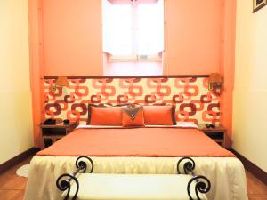 a bedroom with a large bed with an orange headboard at Lima Wari Hotel Boutique in Lima