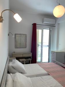 Un dormitorio con una cama grande y una ventana en Ψιλή Άμμος, en Tolo