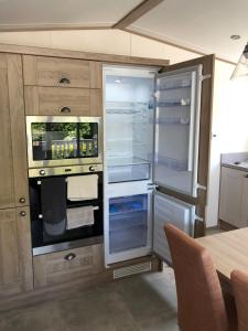 een keuken met een open koelkast en een tafel bij Modern, stylish holiday home in Bembridge