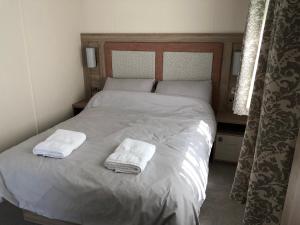 een slaapkamer met een bed met twee handdoeken erop bij Modern, stylish holiday home in Bembridge