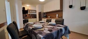 a dining room table with chairs and a kitchen at Klementina in Mali Lošinj