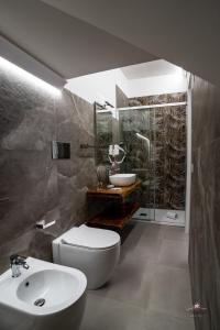 y baño con aseo blanco y lavamanos. en Humboldt Luxury Room Taormina en Taormina