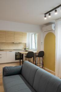 a living room with a couch and a kitchen at Andor apartment near park and subway in Bucharest