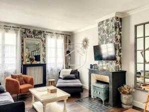 a living room with a fireplace and a tv at Le Donjon des Rois in Dourdan