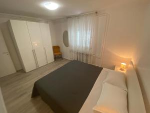 a bedroom with a bed and a chair in it at Klementina in Mali Lošinj