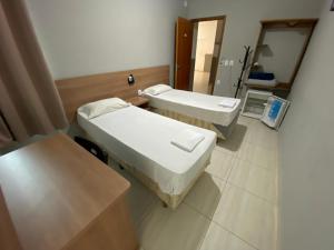 a hospital room with two beds and a mirror at MAPP Hotel Aparecida-SP in Aparecida