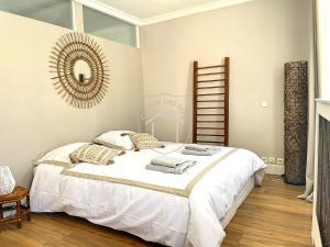 a bedroom with a white bed and a mirror at Le Donjon des Rois in Dourdan