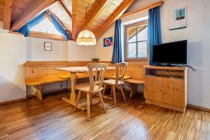 una sala da pranzo con un tavolo e una tv di Lindenhof Apt 1 a Vandoies