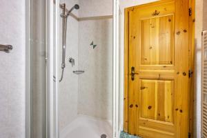 un bagno con vasca e doccia e una porta di Lindenhof Apt 1 a Vandoies Altre 5 foto