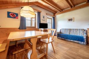 un soggiorno con un tavolo di legno e un divano di Lindenhof Apt 1 a Vandoies