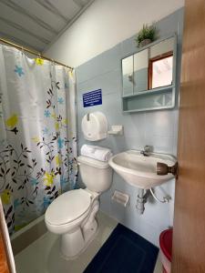 a bathroom with a toilet and a sink at Hotel Rook INN in Paipa