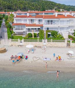 a group of people on a beach with umbrellas at “Sound of the sea” first line studio in Skála Foúrkas