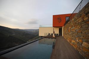 uma casa de vidro com vista para as montanhas em Quinta Vale de Lobos Douro em Folgosa