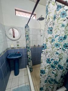 a bathroom with a sink and a shower curtain at Hostal Villamil in Puerto Villamil