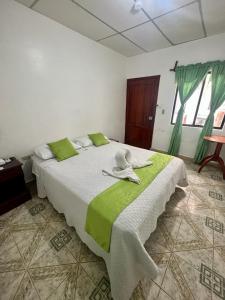 a bedroom with a large bed with a hat on it at Hostal Villamil in Puerto Villamil