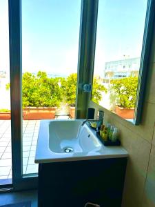 a bathroom sink with a mirror and a window at La mia terrazza sul mare - Mared'aMare in Bari +67 photos