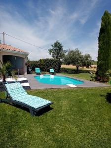 una piscina con 2 tumbonas en un patio en L escapade, en Rabastens