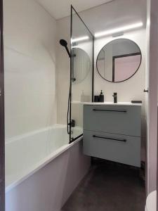 ein weißes Badezimmer mit einem Waschbecken und einem Spiegel in der Unterkunft Studio Gruissan in Gruissan