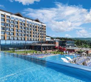a hotel with a large swimming pool with lounge chairs at Fruške Residences in Vrdnik