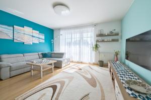 a living room with a couch and a table at Dom & House - Apartments Parkur Sopot in Sopot