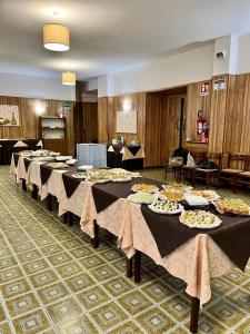 a group of tables with plates of food on them at Hotel Stella Alpina in Villalago