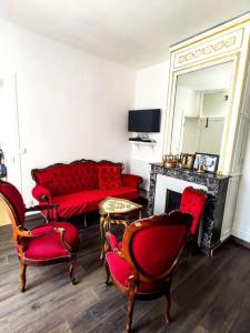 a living room with red furniture and a mirror at Hyper Centre Fontainebleau Villa Beau Soleil in Fontainebleau