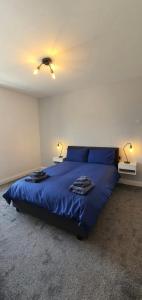 a bedroom with a bed with blue sheets and two lamps at Causeway Coast Sea Shore Apartment - Ballycastle in Ballycastle