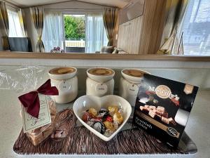 a table with a bowl of candy and a book at Highland Holiday Getaways in Embo
