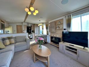 a living room with a large flat screen tv at Highland Holiday Getaways in Embo