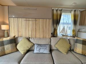 uma sala de estar com um sofá com almofadas em Highland Holiday Getaways em Embo