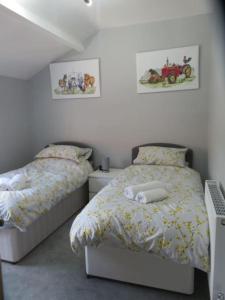 um quarto com duas camas e duas fotografias na parede em 2 Railway Terrace 