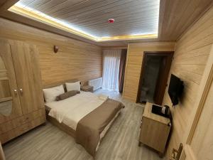 a bedroom with a large bed and a television at Haros Suite Hotel in Uzungol