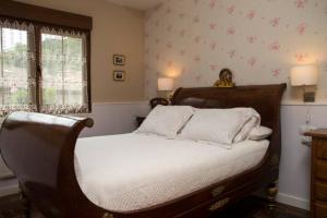 a bedroom with a bed with white sheets and a window at Casa La Bolera in Carreña de Cabrales 