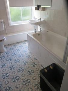 a bathroom with a tub and a sink and a toilet at 2 Railway Terrace in Croft +25 photos