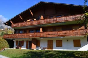 - un grand bâtiment avec des balcons en bois dans l'établissement Cozy apartment in the heart of the Alps, à Château-d'Oex