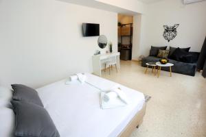 a bedroom with a white bed and a living room at Old Town Hall Suites and Apartments in Athens