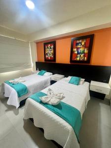two beds in a room with stained glass windows at Hostal Villamil in Puerto Villamil
